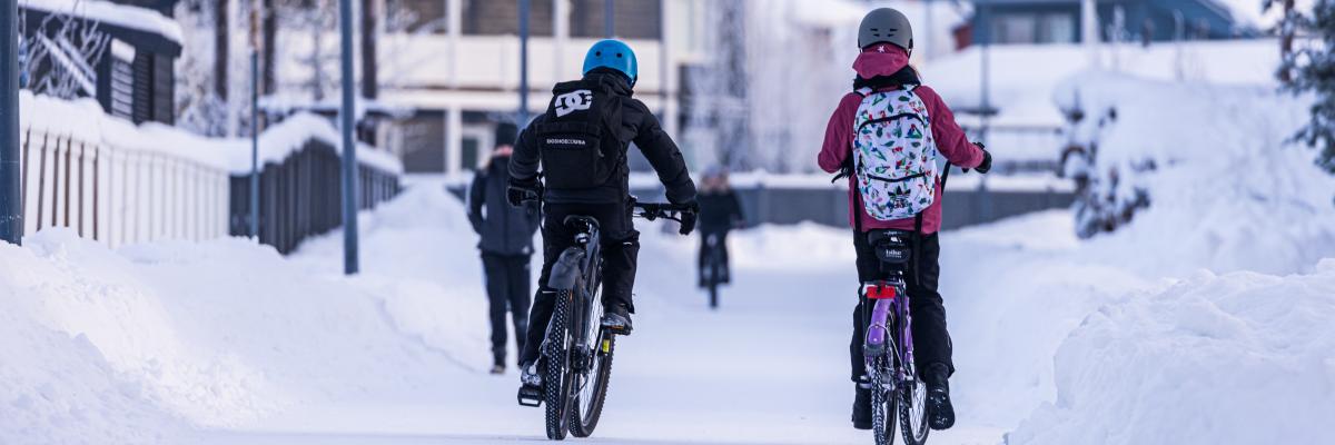 Lapset pyöräilemässä talvisäässä 