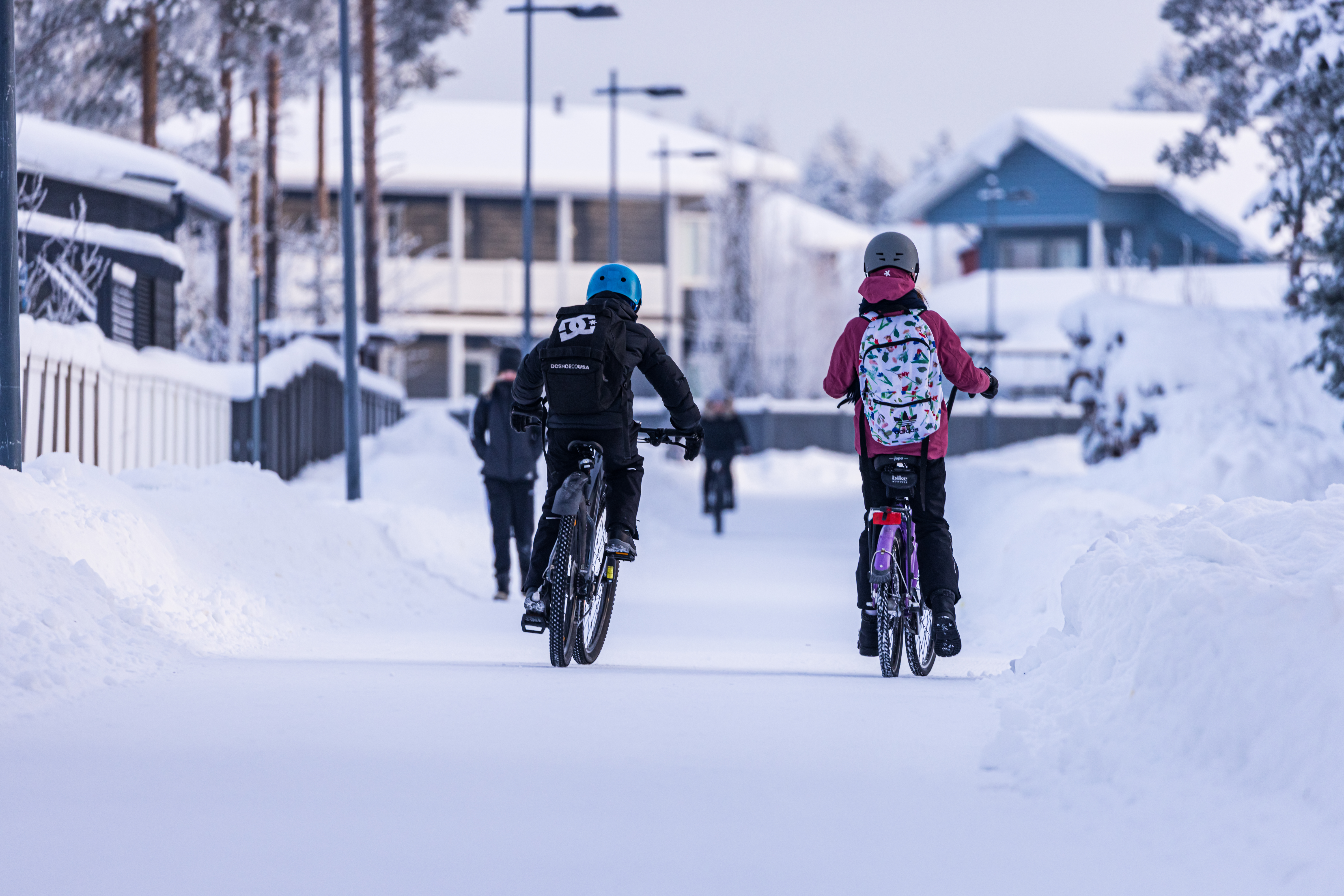 Lapset pyöräilemässä talvisäässä 