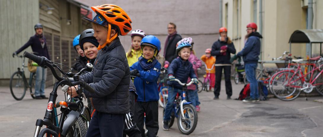 Päiväkotilaisia pihamaalla pyörien kanssa