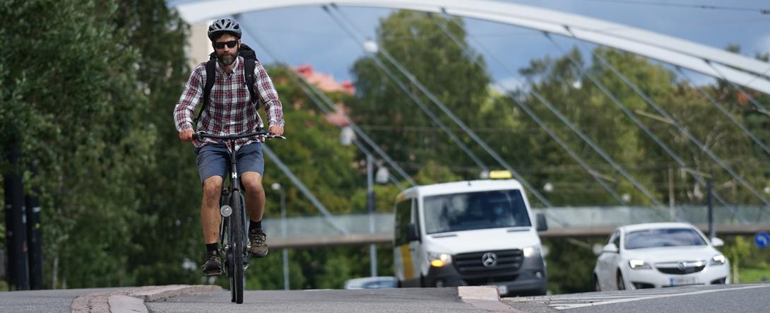 Mies pyöräilee Helsingissä